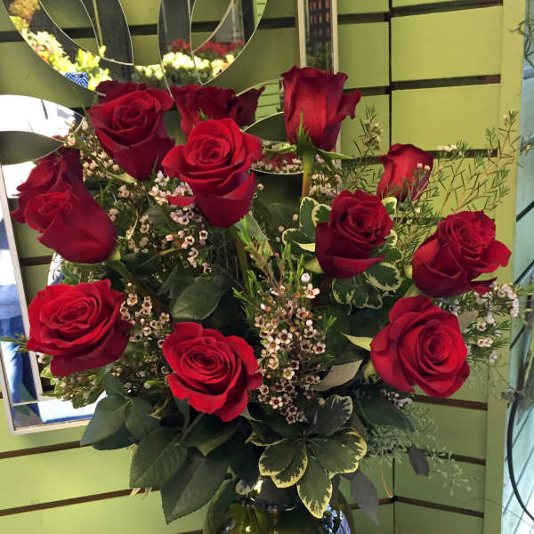 Red roses arranged in a clear glass vase