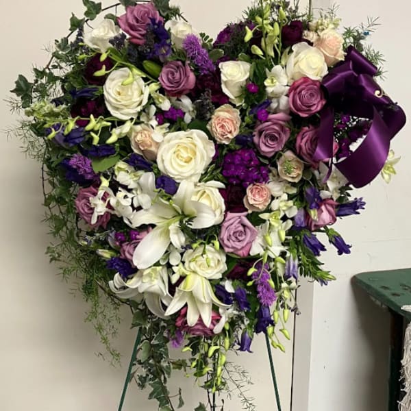 Large purple, white, and pink floral standing spray on an easel