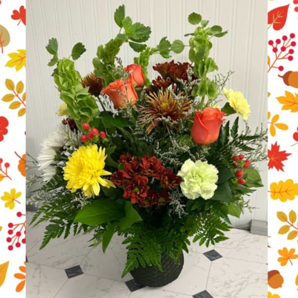 Mixed flower arrangement in a black vase with roses and chrysanthemums