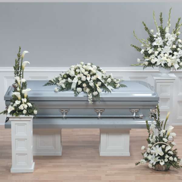White funeral casket with white floral sprays and arrangements