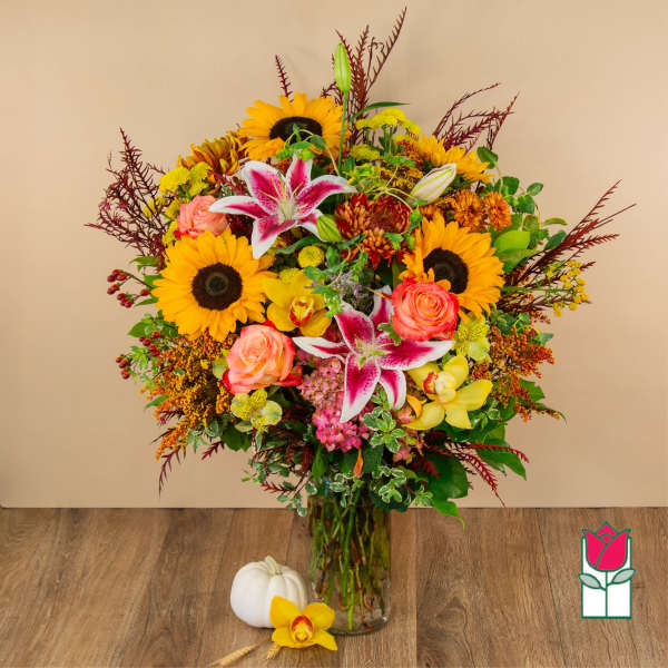 Mixed bouquet in a glass vase with sunflowers, lilies, and roses