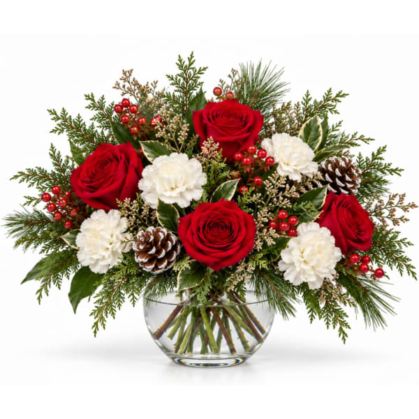 Red roses and white carnations in a clear glass vase with pinecones
