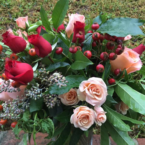Bouquet of red and blush roses with berry accents