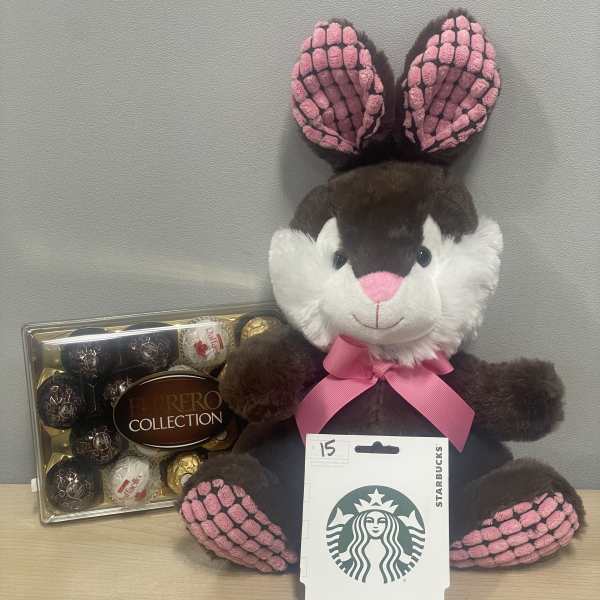 Plush bunny with a pink ribbon beside a Ferrero Rocher box and Starbucks card
