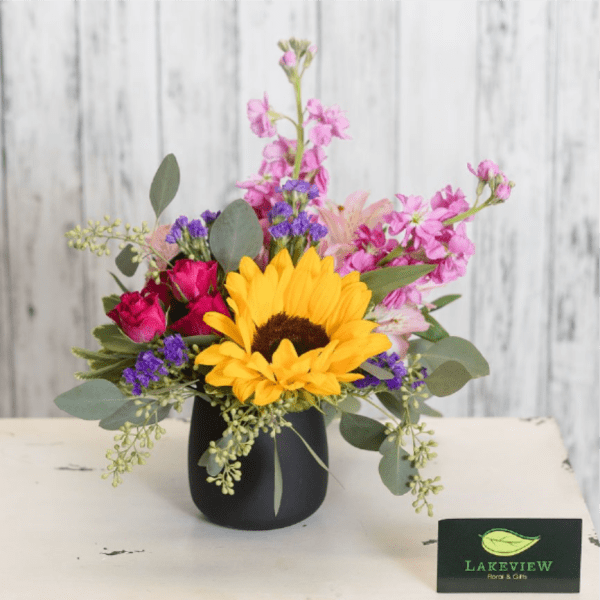 Mixed bouquet with a sunflower in a black vase