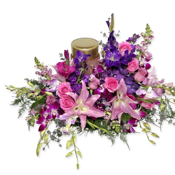 Pink and purple floral arrangement with a candle centerpiece