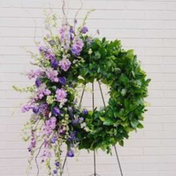 Purple floral wreath on a metal stand