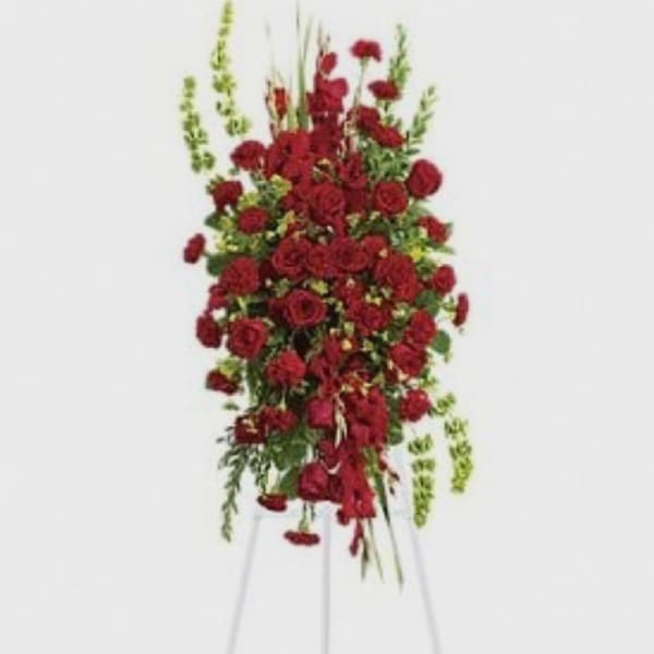 Tall standing spray of red roses on a metal easel