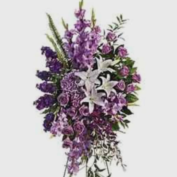 Tall purple and white funeral spray on a stand