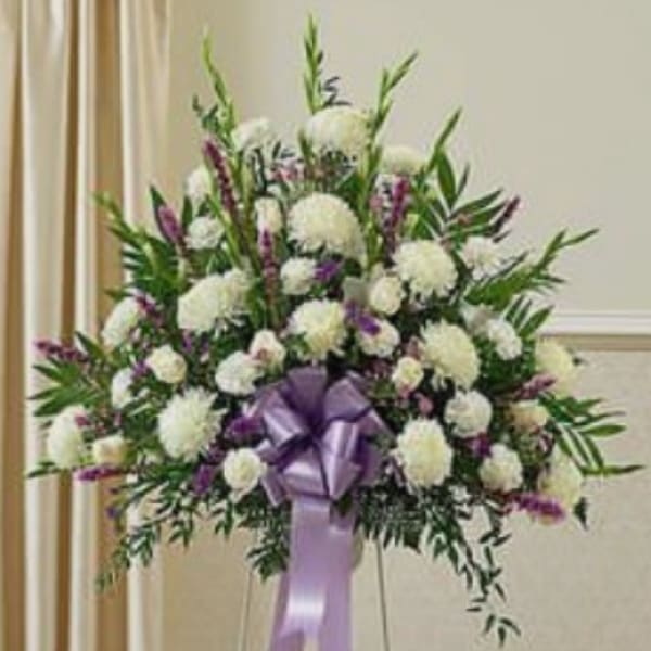 Large white and purple floral standing spray with a lavender ribbon