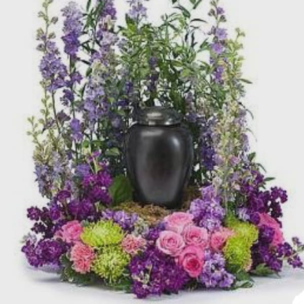 Purple and pink floral arrangement in a black urn vase