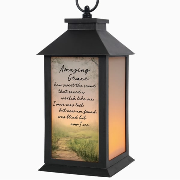 Black lantern with a printed "Amazing Grace" panel and warm light inside