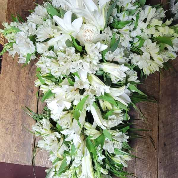 White floral spray with lilies and alstroemeria arranged in a cascading shape