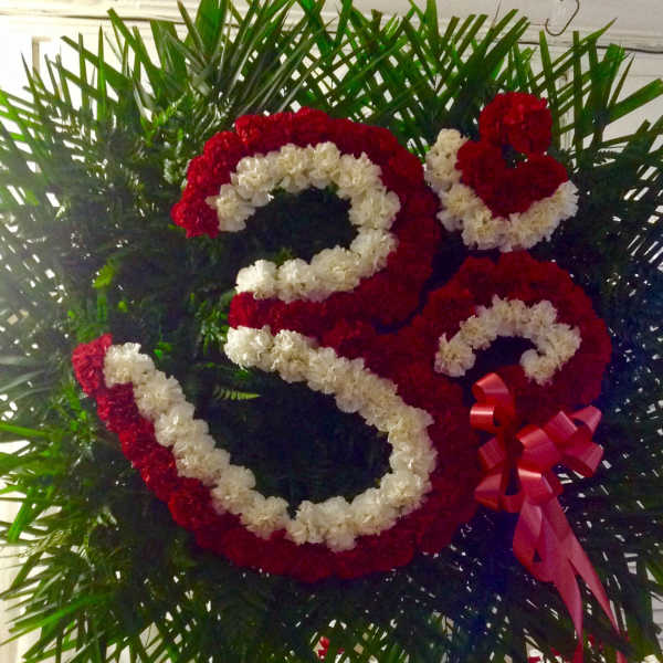 Large floral number 25 made of red and white flowers with a red ribbon