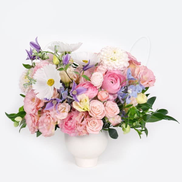 Pastel bouquet in a white vase with pink, white, and purple flowers