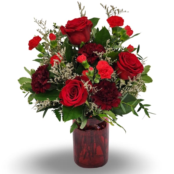 Red roses and carnations in a red glass vase