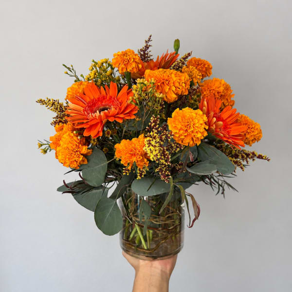 Orange and yellow mixed bouquet in a clear glass vase