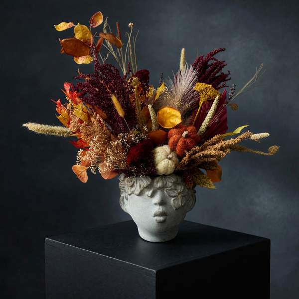 Autumn floral arrangement in a sculpted face vase