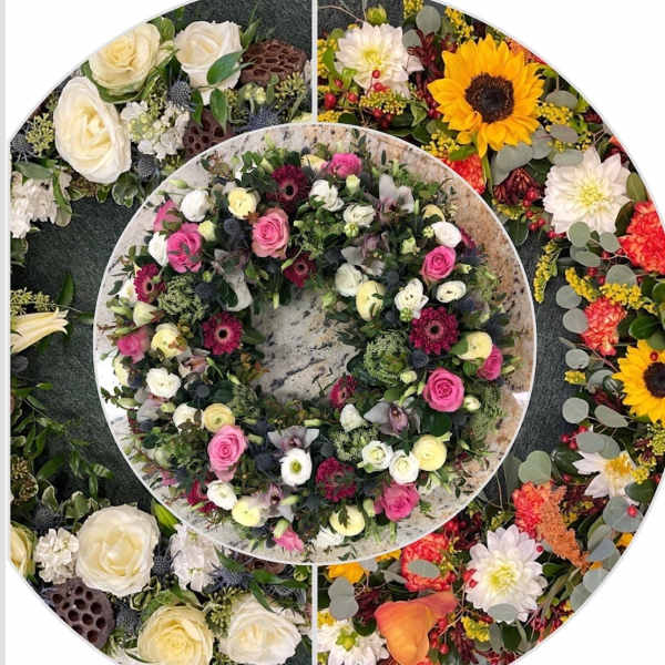 Circular floral wreath with pink, white, and yellow blooms