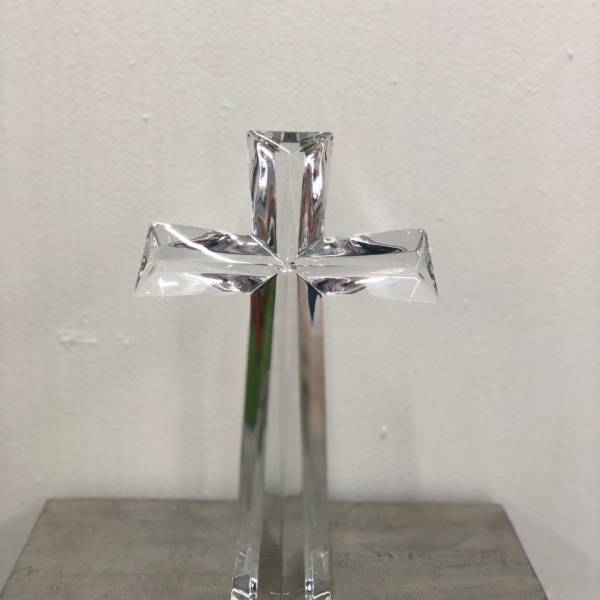Clear glass cross standing on a surface