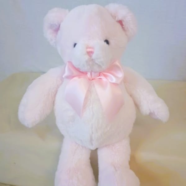 White teddy bear with a pink satin bow