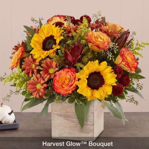 Bouquet of sunflowers, roses, and mums in a wooden cube vase