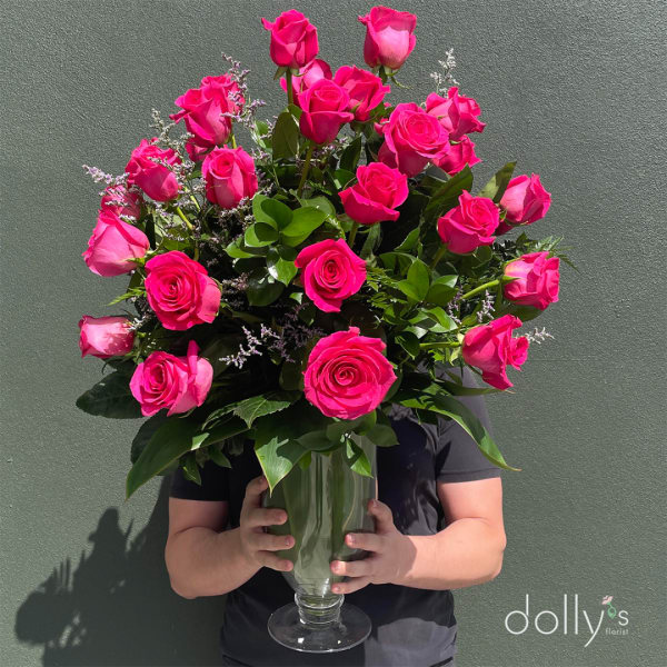 Tall bouquet of hot pink roses in a clear glass vase