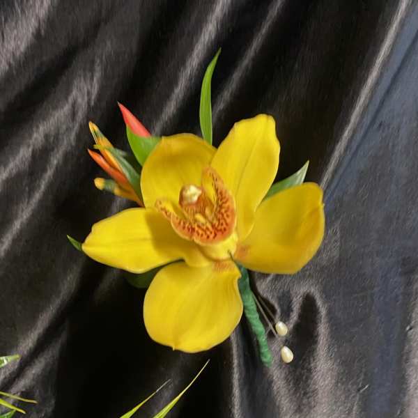 Yellow orchid corsage with small orange accents on black fabric