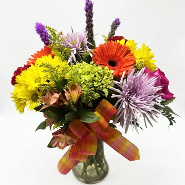 Colorful mixed bouquet in a glass vase with a plaid ribbon