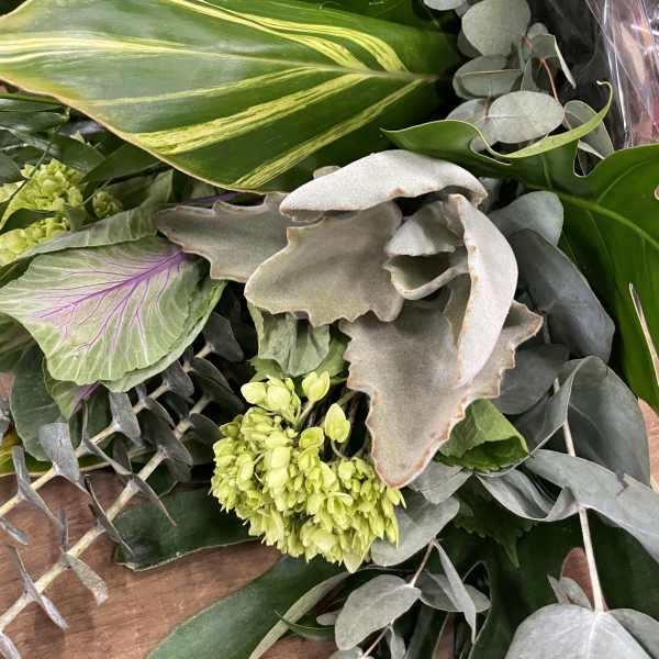 Bouquet of assorted green foliage with a few pale green blooms