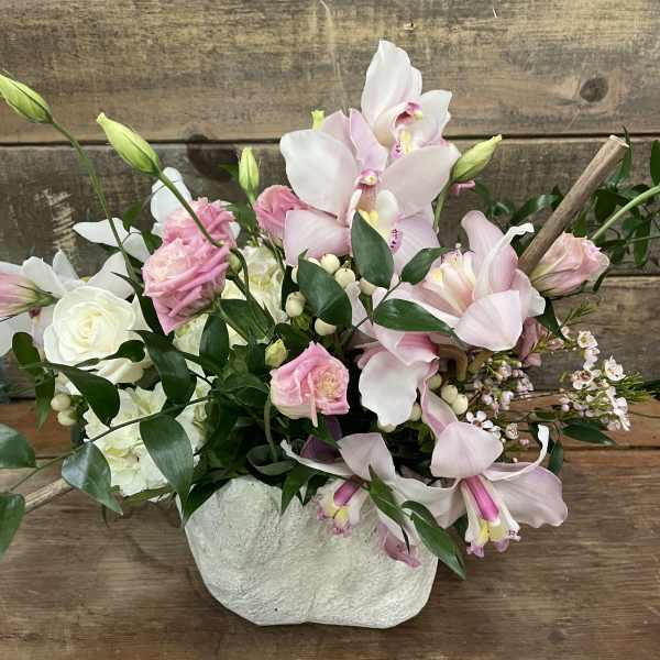 Pink and white orchid bouquet in a textured white vase
