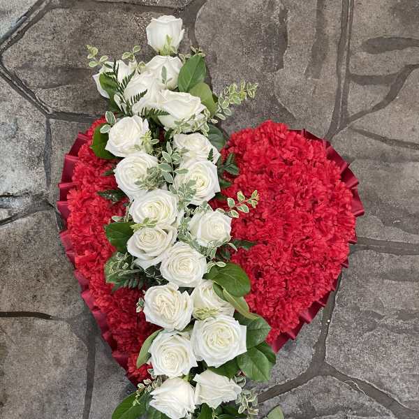 Heart-shaped red floral arrangement with white roses and greenery