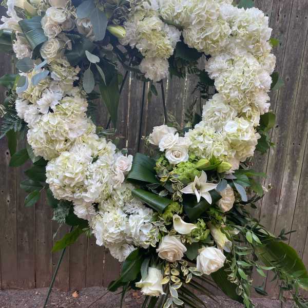 Large white floral heart wreath on a stand
