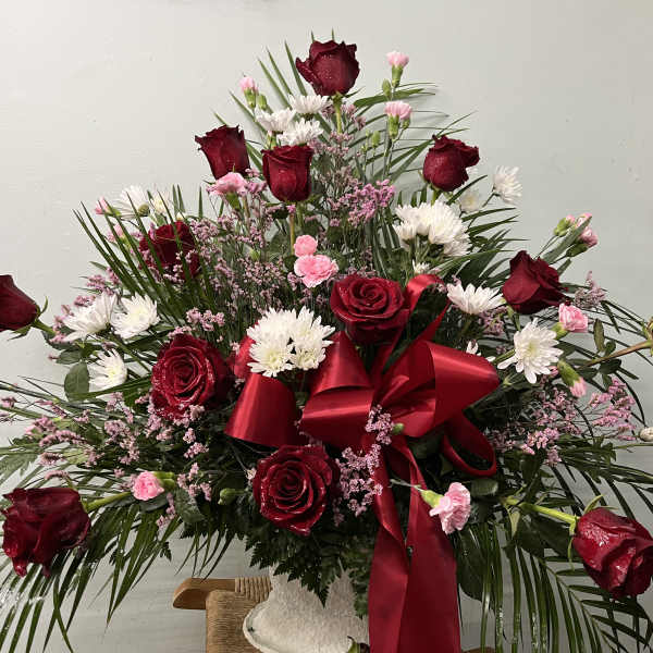 Large bouquet of red roses and white daisies with a red ribbon