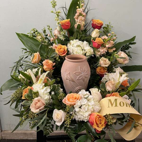 Large floral arrangement with roses, lilies, and a pink vase centerpiece