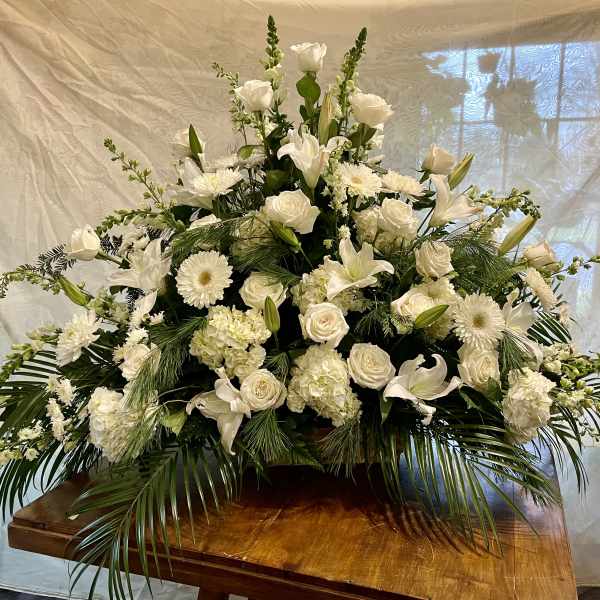 Large white floral arrangement with roses, lilies, and daisies