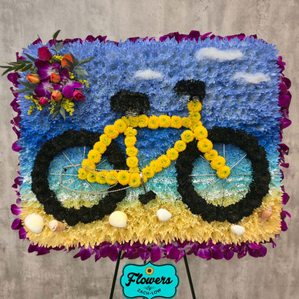 Bicycle-shaped floral display with blue, yellow, and purple flowers