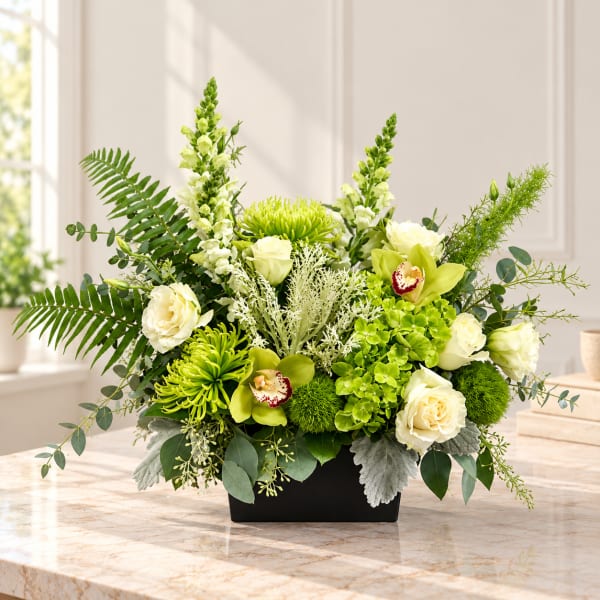 Green and white floral arrangement in a black rectangular vase