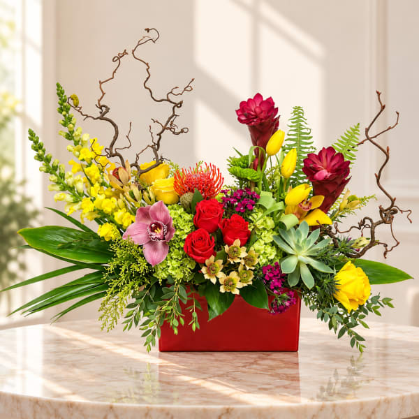 Colorful mixed flower arrangement in a red rectangular vase
