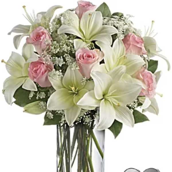 Pink roses and white lilies in a clear glass vase
