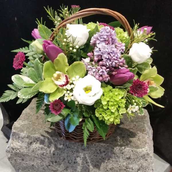 Mixed flower basket with purple, white, and green blooms