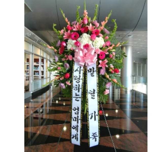 Tall standing pink and white flower spray with large bow and Korean message ribbons