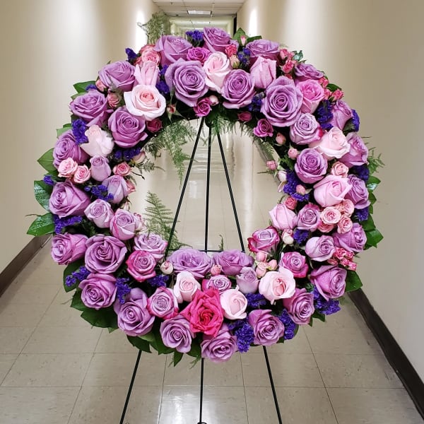 Standing wreath of lavender and pink roses on a black easel