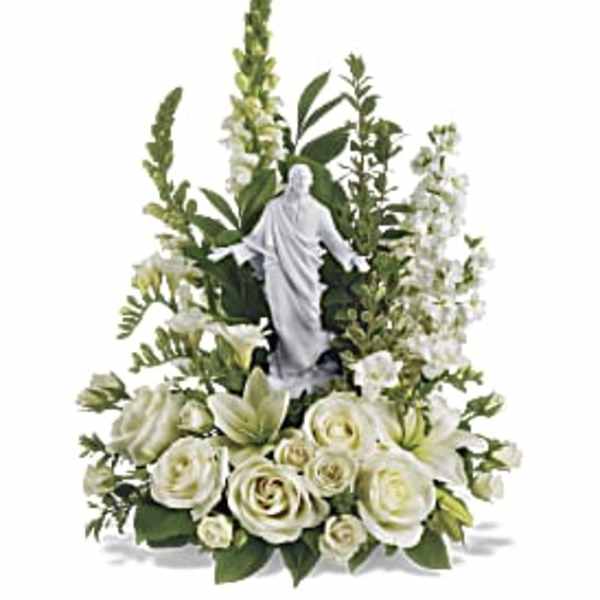White floral arrangement with a religious statue centerpiece