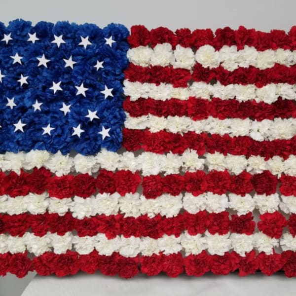 Floral arrangement shaped like the American flag in red, white, and blue