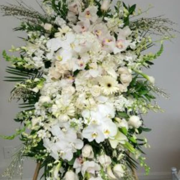 Large white floral standing arrangement with orchids and lilies
