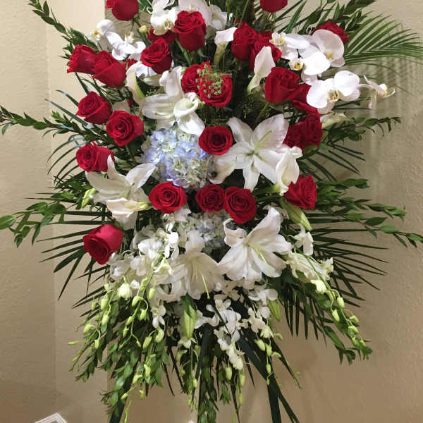 Standing floral spray with red roses, white lilies, and orchids