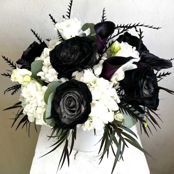Black and white floral arrangement in a white vase