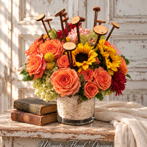 Bright mixed bouquet in a glass vase with sunflowers, roses, and hydrangeas