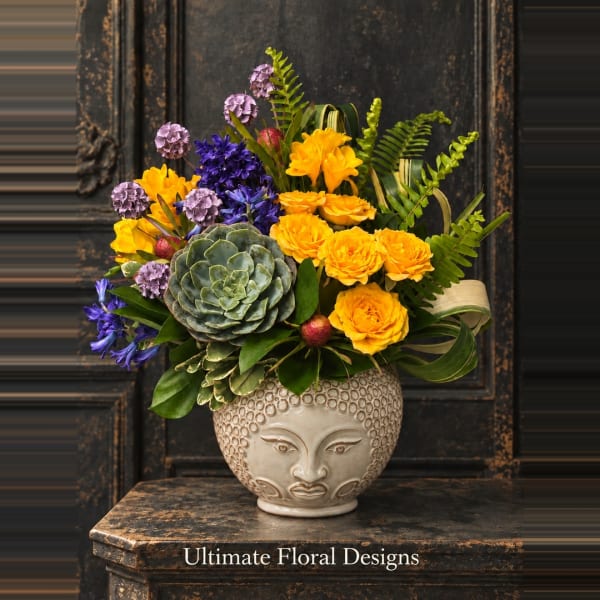 Colorful bouquet in a sculpted ceramic vase with a face design